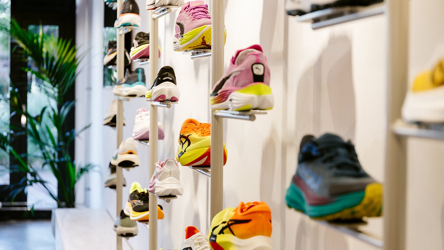 Schoenenwand met hardloopschoenen in de winkel van DailyRun