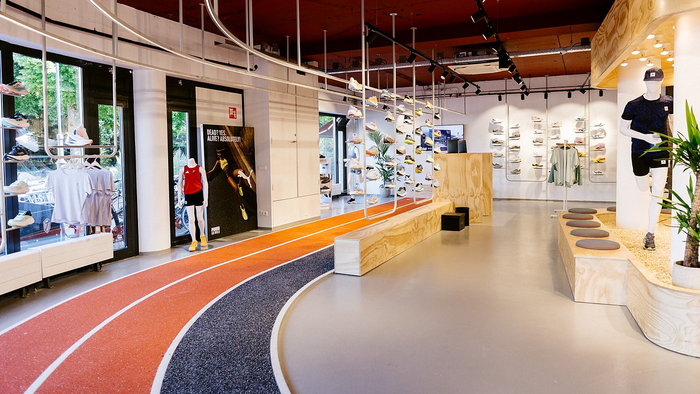 Interieur van DailyRun Haarlem met de looptestbaan en schoenenwand